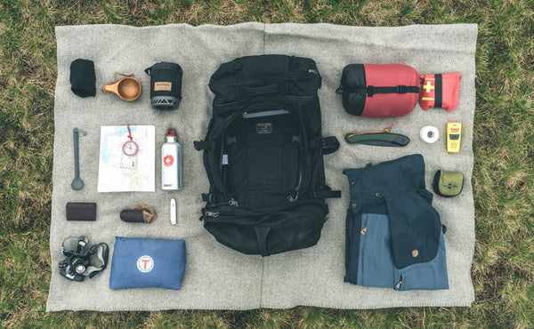 A possible load out of the Hero's Journey, including packing cubes, jacket, first aid kit, mugs, thermoses, camera and maps.